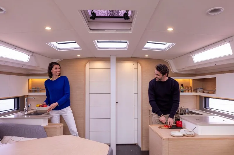 Slide: The Image of Spacious interior of 2024 Dufour 44 yacht with modern kitchen and natural lighting. - 8