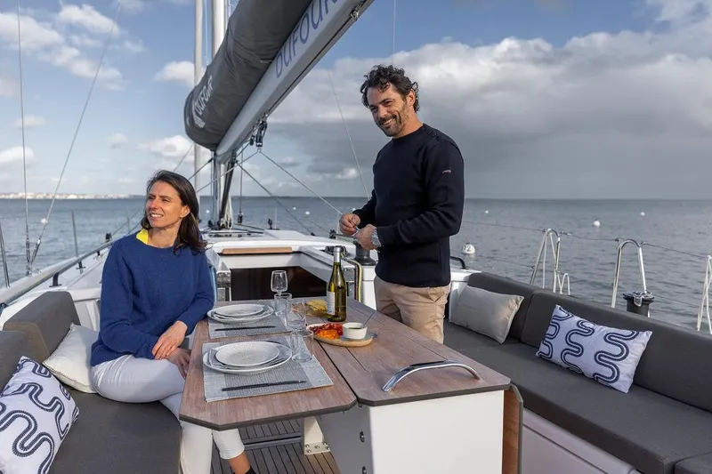 Slide: The Image of Couple enjoying a meal on the deck of a 2024 Dufour 44 sailboat. - 3