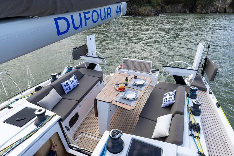 Slide: The Image of Luxury 2024 Dufour 44 sailboat with elegant outdoor dining setup. - 3