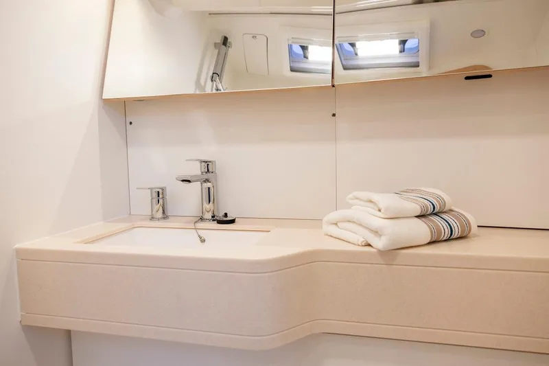 Slide: The Image of Modern bathroom sink area in 2024 Dufour 44 yacht with towels and mirror. - 12