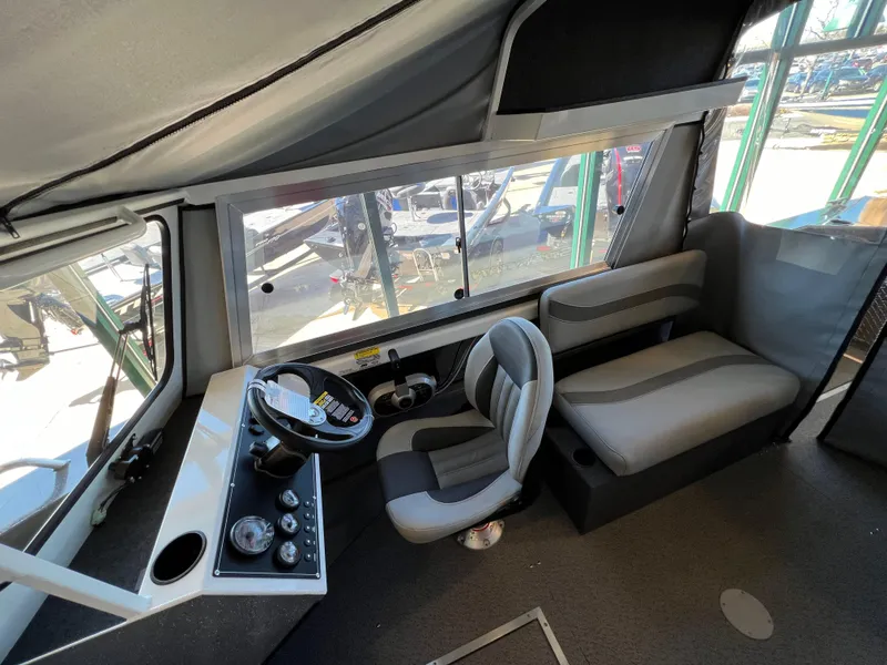 Slide: The Image of 2024 Spartan 185 Astoria boat interior with helm, captain's chair, and passenger seating. - 10