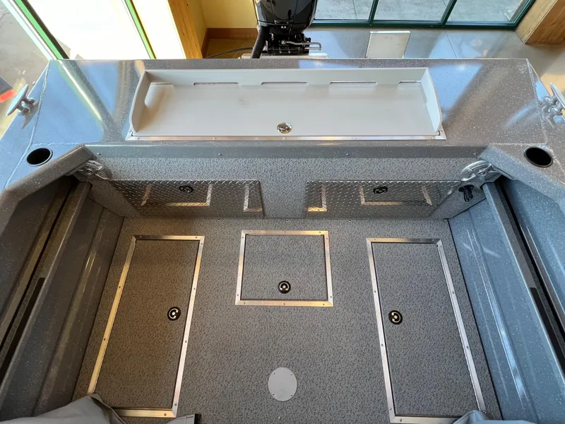 Slide: The Image of 2024 Spartan 185 Astoria boat interior with storage compartments and motor. - 11