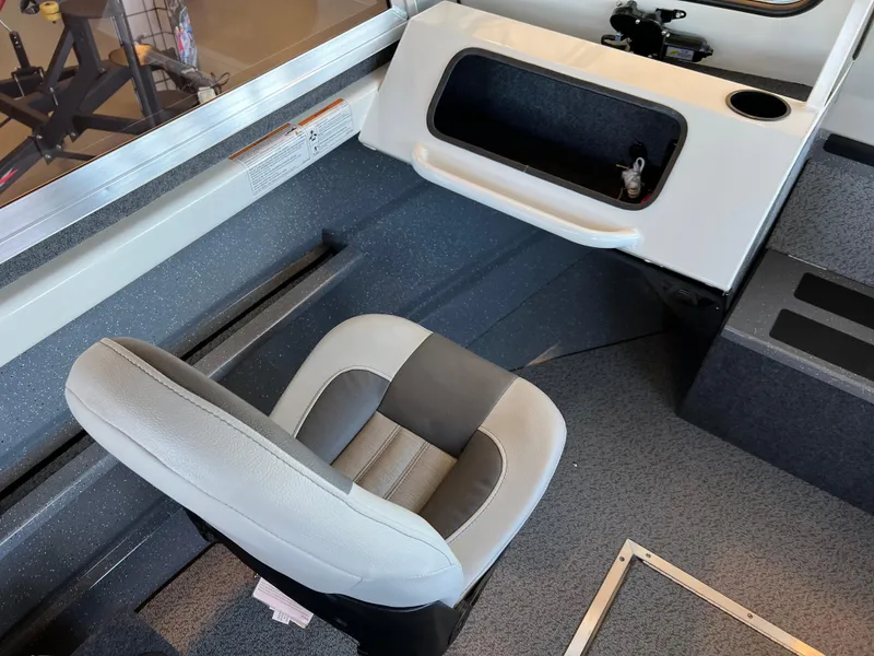 Slide: The Image of 2024 Spartan 185 Astoria boat interior with captain's chair and storage compartment. - 7
