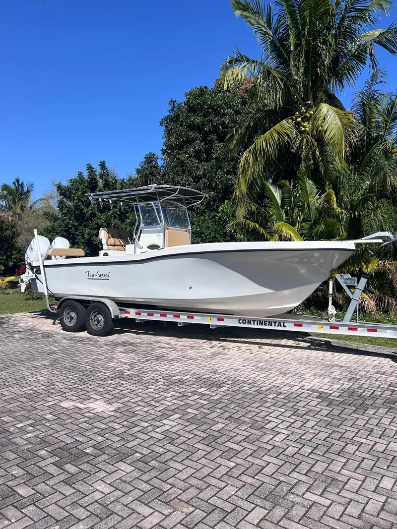 The Image of 2022 Dusky 278 Center Console boat on a trailer in a tropical setting. - 1