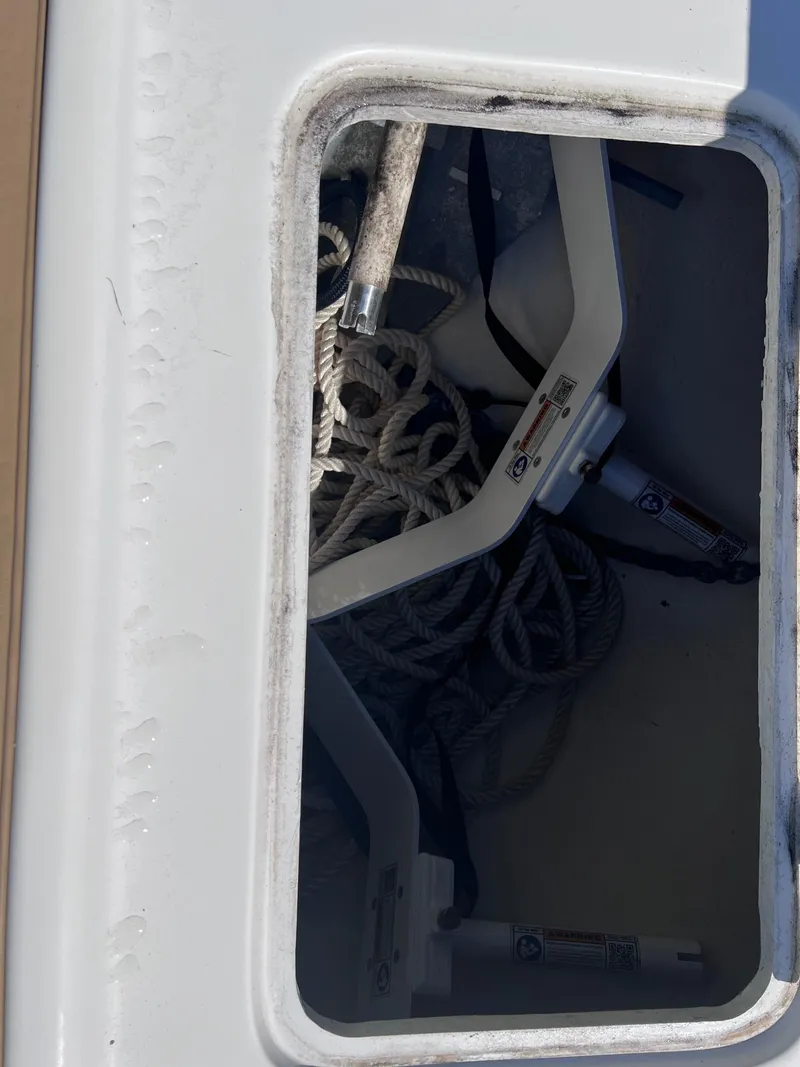 Slide: The Image of Storage compartment of a 2022 Dusky 278 Center Console boat with ropes and equipment. - 10