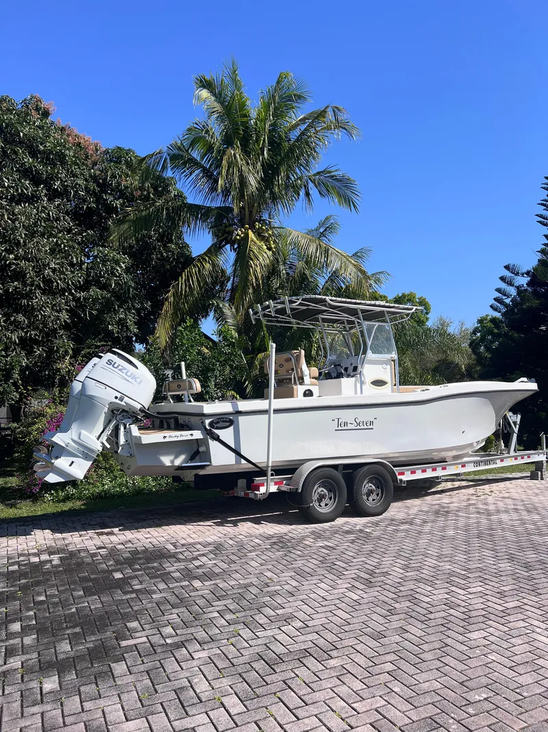 Slide: The Image of 2022 Dusky 278 Center Console boat on a trailer, parked on a paved driveway. - 2