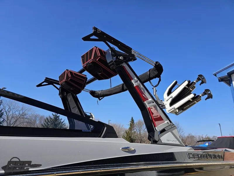 Slide: The Image of 2021 Centurion Ri265 boat with wakeboard tower and speakers against a clear blue sky. - 12