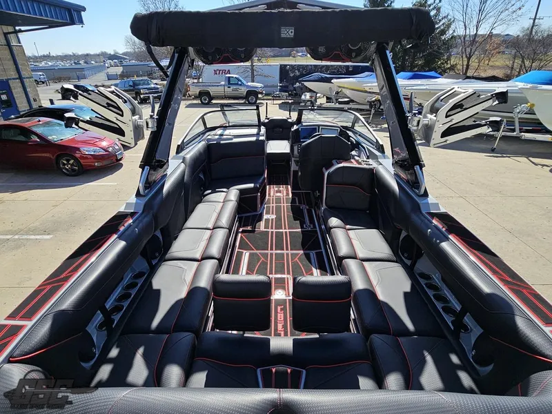 Slide: The Image of 2021 Centurion Ri265 boat interior with black and red seating, docked at a marina. - 25