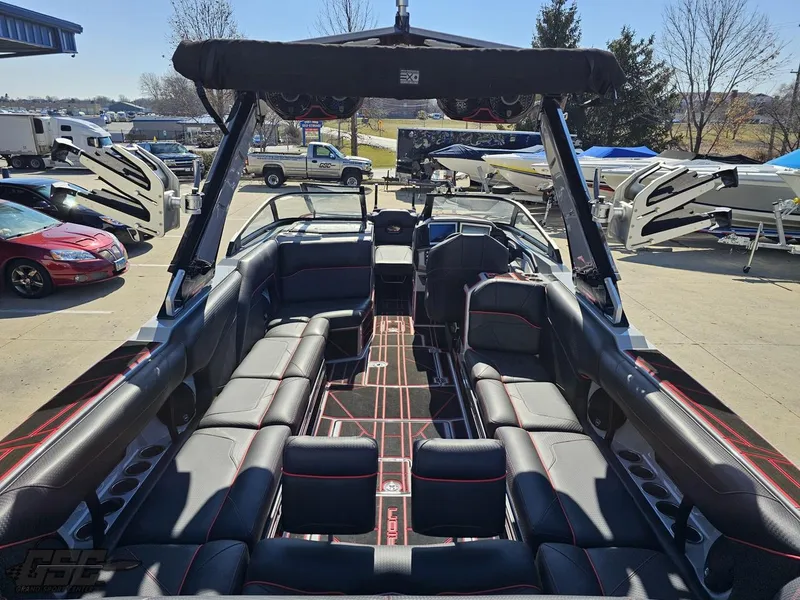 Slide: The Image of 2021 Centurion Ri265 boat interior with black and red seating, docked at a marina. - 26