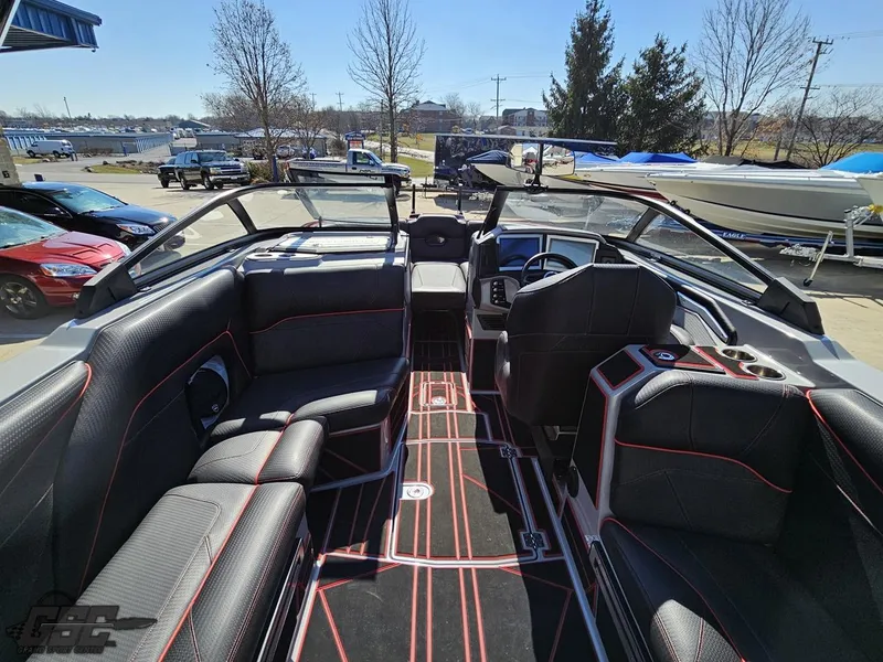 Slide: The Image of 2021 Centurion Ri265 boat interior with black and red seating, dashboard, and open bow. - 30