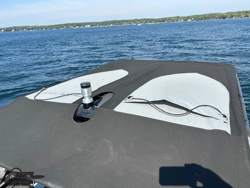 Slide: The Image of 2021 Centurion Ri265 boat on a lake with a covered deck. - 49