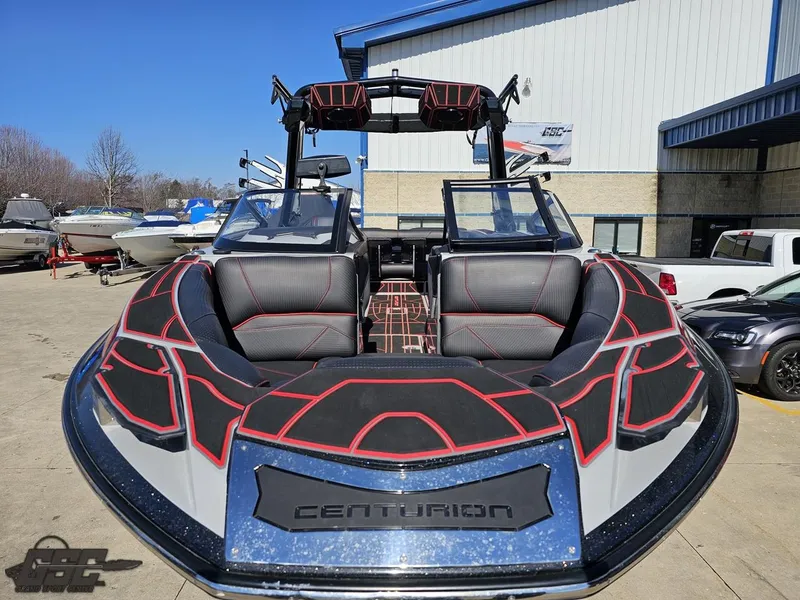 Slide: The Image of 2021 Centurion Ri265 boat with black and red interior, docked outside a warehouse. - 7