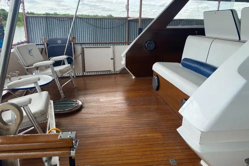 Slide: The Image of 1969 Chris-Craft 46 Roamer boat deck with wooden flooring and seating area. - 11