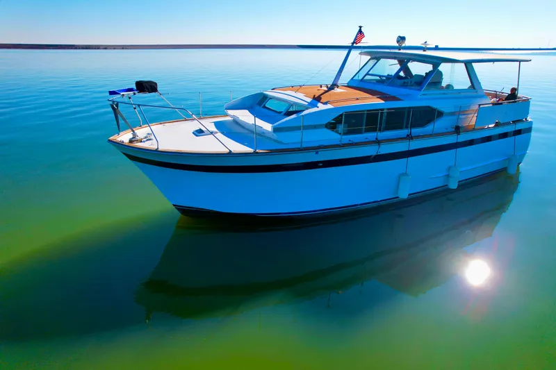 Slide: The Image of 1969 Chris-Craft 46 Roamer yacht on calm water under clear blue sky. - 17