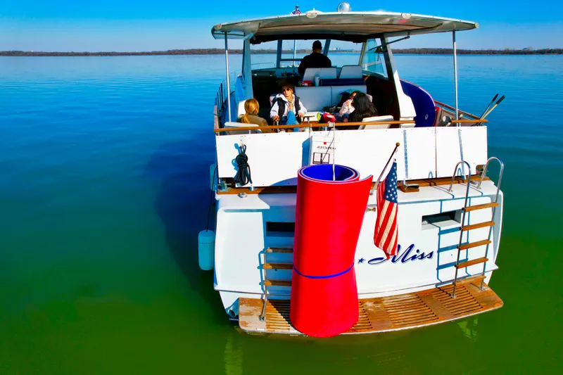 Slide: The Image of 1969 Chris-Craft 46 Roamer yacht on calm water with people relaxing on deck. - 18