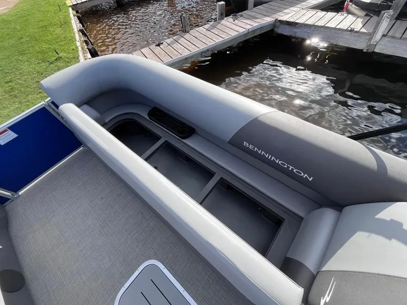 Slide: The Image of 2024 Bennington 22SVL-SPS pontoon boat interior with gray seating by a dock. - 11