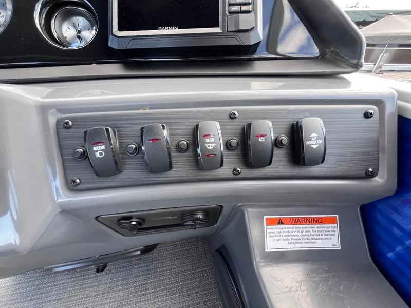 Slide: The Image of Dashboard controls of 2024 Bennington 22SVL-SPS boat with switches and warning label. - 26
