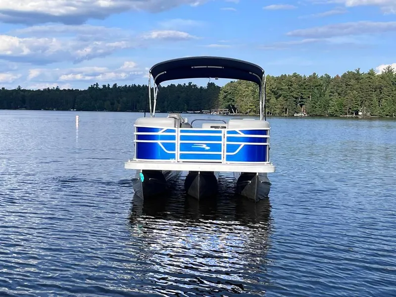 Slide: The Image of 2024 Bennington 22SVL-SPS pontoon boat on a serene lake with forest backdrop. - 3
