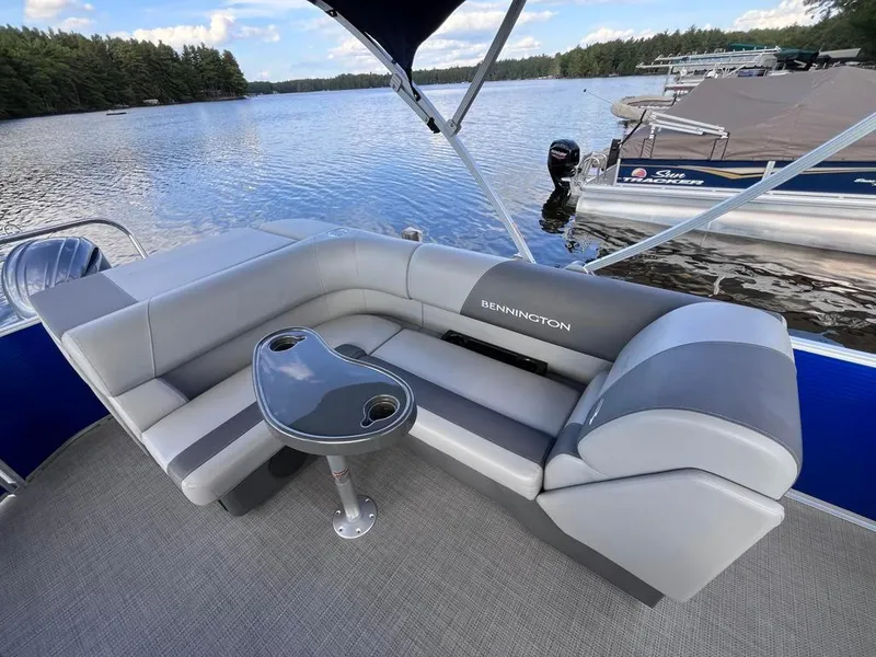 Slide: The Image of 2024 Bennington 22SVL-SPS pontoon boat with comfortable seating on a serene lake. - 30