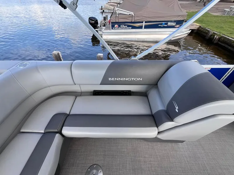 Slide: The Image of 2024 Bennington 22SVL-SPS pontoon boat with gray seating, docked by the water. - 31