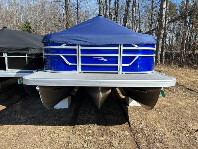 Slide: The Image of 2024 Bennington 22SVL-SPS pontoon boat with blue cover, parked on dry land. - 39