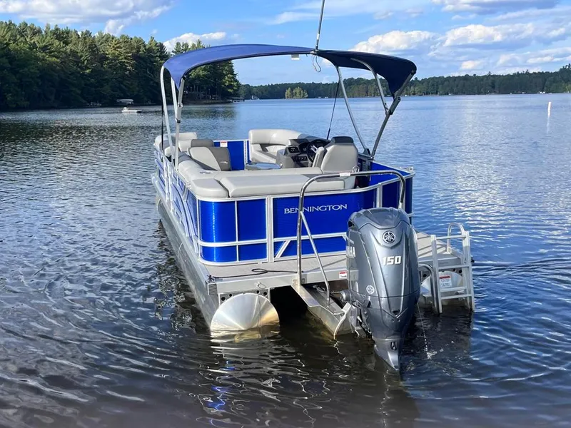 Slide: The Image of 2024 Bennington 22SVL-SPS pontoon boat on a serene lake. - 4