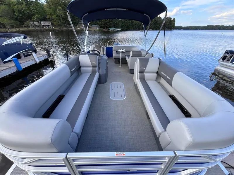 Slide: The Image of 2024 Bennington 22SVL-SPS pontoon boat with spacious seating on a serene lake. - 6