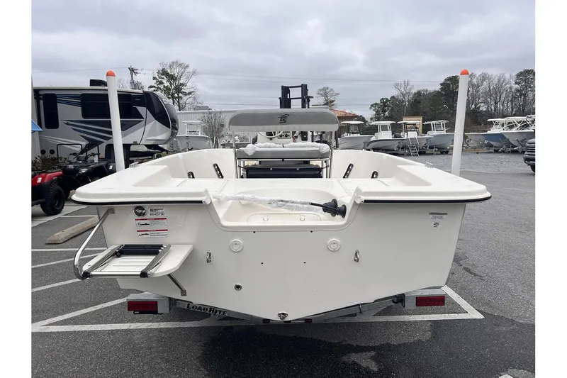 Slide: The Image of 2024 Carolina Skiff EV180 Sea Skiff boat, rear view, parked in a marina. - 6