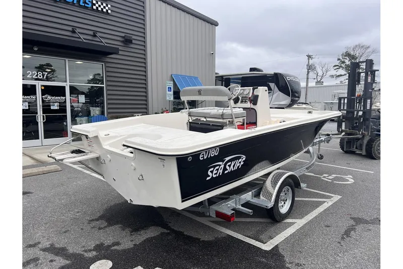 Slide: The Image of 2024 Carolina Skiff EV180 Sea Skiff boat on a trailer outside a dealership. - 3