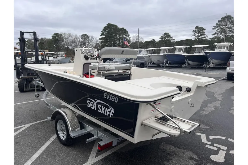 Slide: The Image of 2024 Carolina Skiff EV180 boat on trailer in marina parking lot. - 4