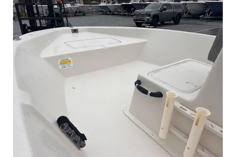 Slide: The Image of 2024 Carolina Skiff EV180 boat interior with storage compartments and rod holders. - 7