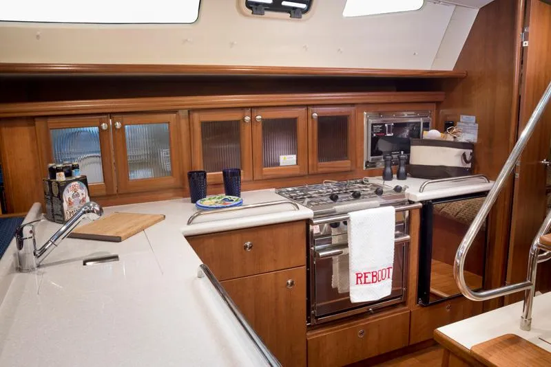Slide: The Image of Modern kitchen in a 2016 Marlow-Hunter 37 sailboat with wooden cabinets and stainless steel appliances. - 14