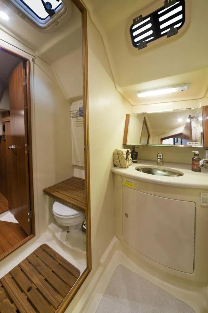 Slide: The Image of 2016 Marlow-Hunter 37 yacht bathroom with sink, mirror, and wooden accents. - 16