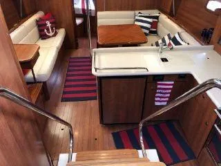 Slide: The Image of Interior of 2016 Marlow-Hunter 37 sailboat with wood finish, seating area, and galley. - 7