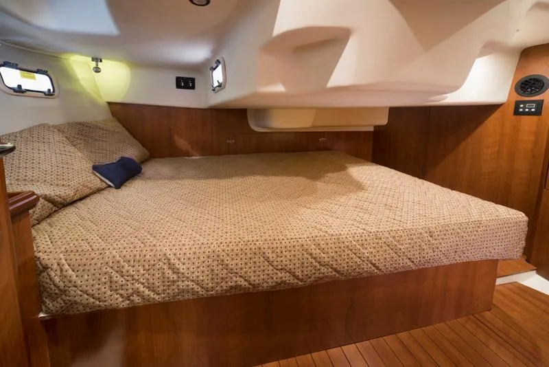 Slide: The Image of 2016 Marlow-Hunter 37 yacht interior cabin with a cozy bed and wooden finish. - 9