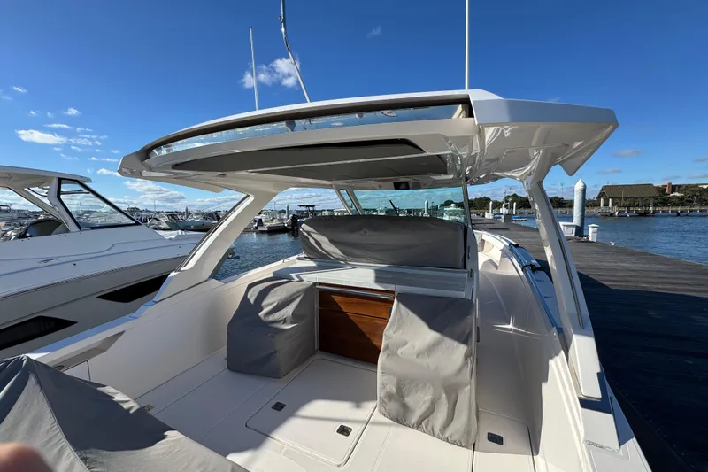 Slide: The Image of 2019 Tiara Sport 38 LS boat docked, featuring sleek design and spacious seating area. - 12