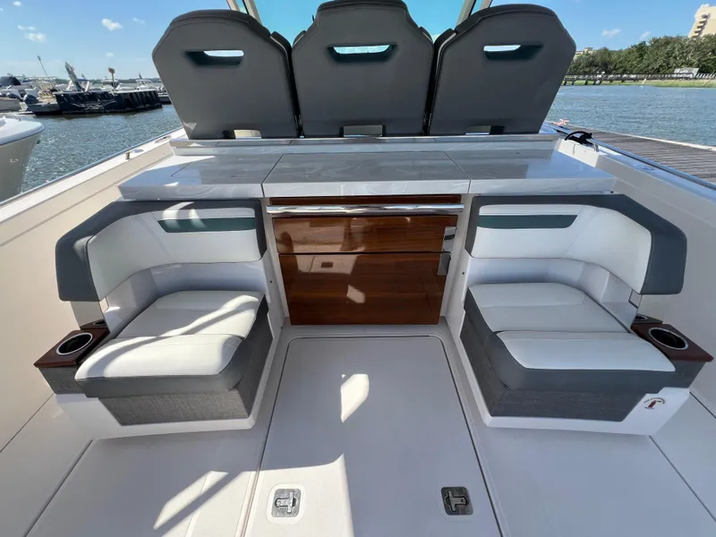 Slide: The Image of 2019 Tiara Sport 38 LS boat interior with seating and storage, docked by the water. - 22