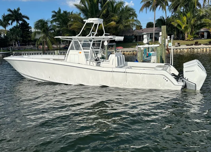 Slide: The Image of 2018 Invincible 39 Open Fisherman boat on water, surrounded by palm trees. - 13