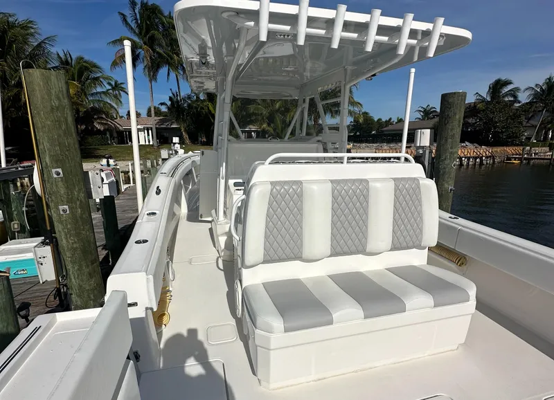 Slide: The Image of 2018 Invincible 39 Open Fisherman boat with cushioned seating, docked by palm trees. - 3