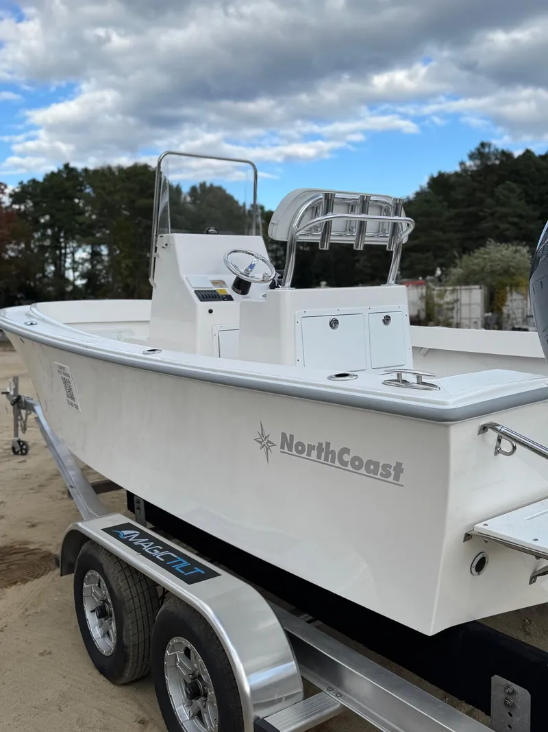 Slide: The Image of 2024 NorthCoast 190 boat on trailer, white exterior, parked outdoors under cloudy sky. - 6
