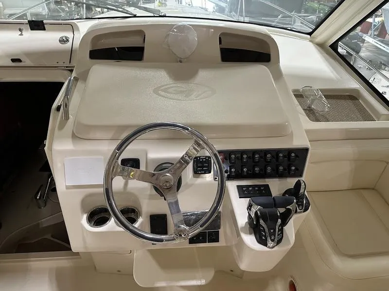 Slide: The Image of 2024 Grady-White Express 330 helm station with steering wheel and control panel. - 13