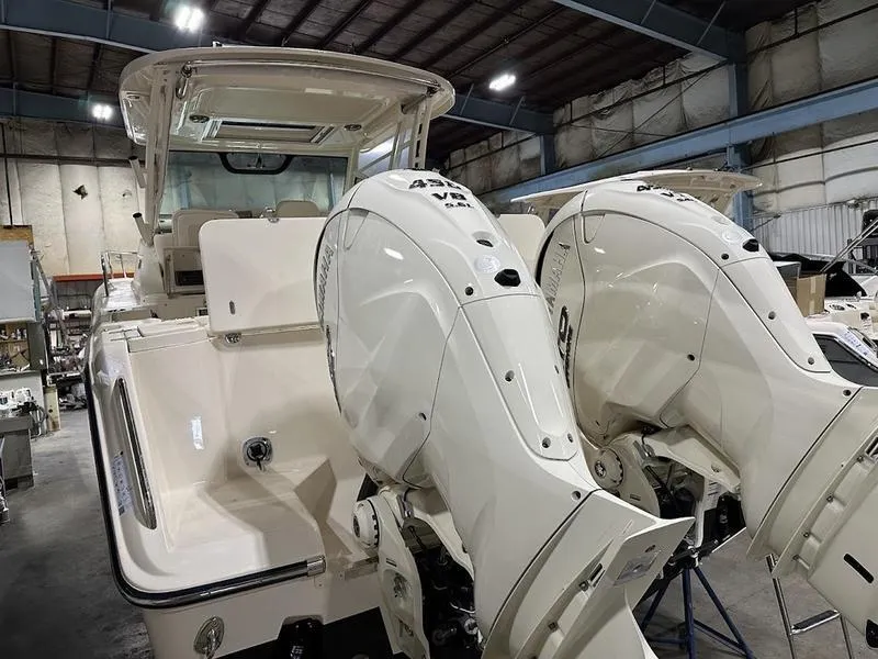 Slide: The Image of 2024 Grady-White Express 330 boat with twin outboard engines in a warehouse. - 5