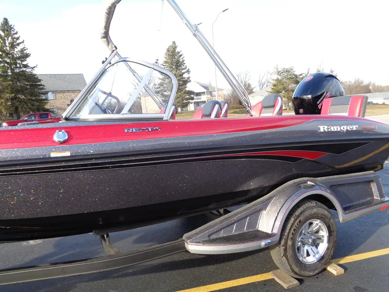 Slide: The Image of 2024 Ranger 1850 Reata boat with red and black exterior on a trailer. - 12