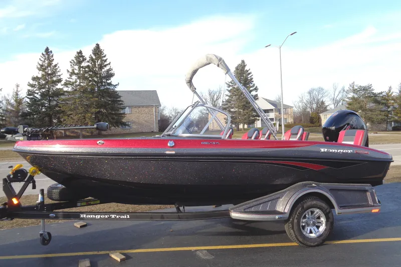 Slide: The Image of 2024 Ranger 1850 Reata boat on trailer, black and red, parked outdoors. - 8