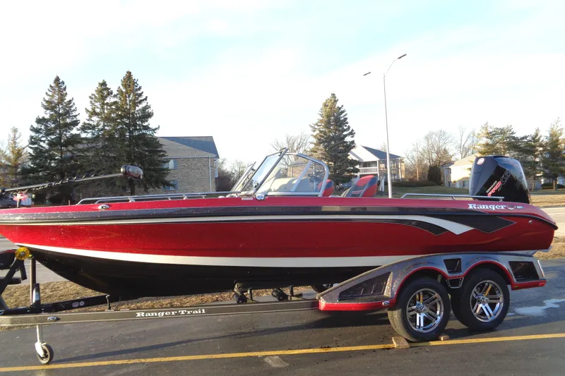 Slide: The Image of 2024 Ranger 621 FS PRO boat on trailer, red and black, parked outdoors. - 1