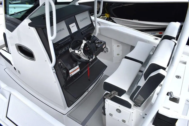 Slide: The Image of 2024 Blackfin 272CC boat cockpit with Garmin navigation system and seating. - 17