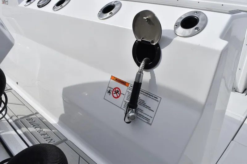 Slide: The Image of 2024 Blackfin 272CC boat fuel station with hose and warning label. - 33