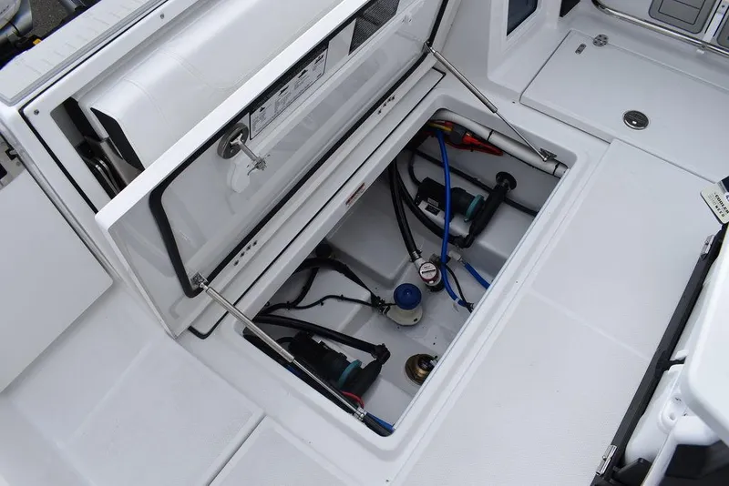 Slide: The Image of 2024 Blackfin 272CC boat storage compartment with open hatch and visible wiring. - 39