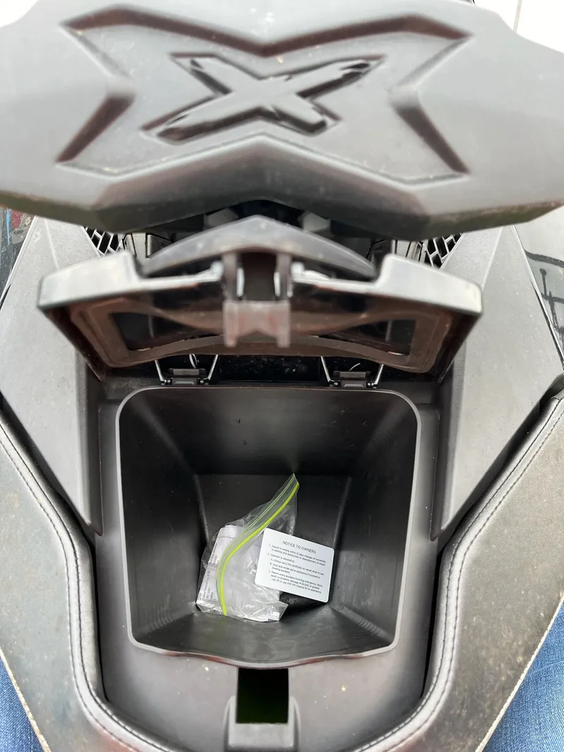 Slide: The Image of 2017 Bombardier Sea Doo GTR 230 storage compartment with open lid and contents inside. - 13