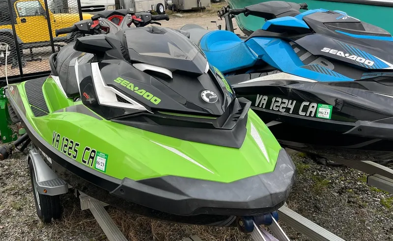 Slide: The Image of 2017 Bombardier Sea Doo GTR 230 jet skis in green and blue on trailer. - 17